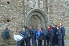 Pupils looking at Putlog holes in the walls at Clonmacnois